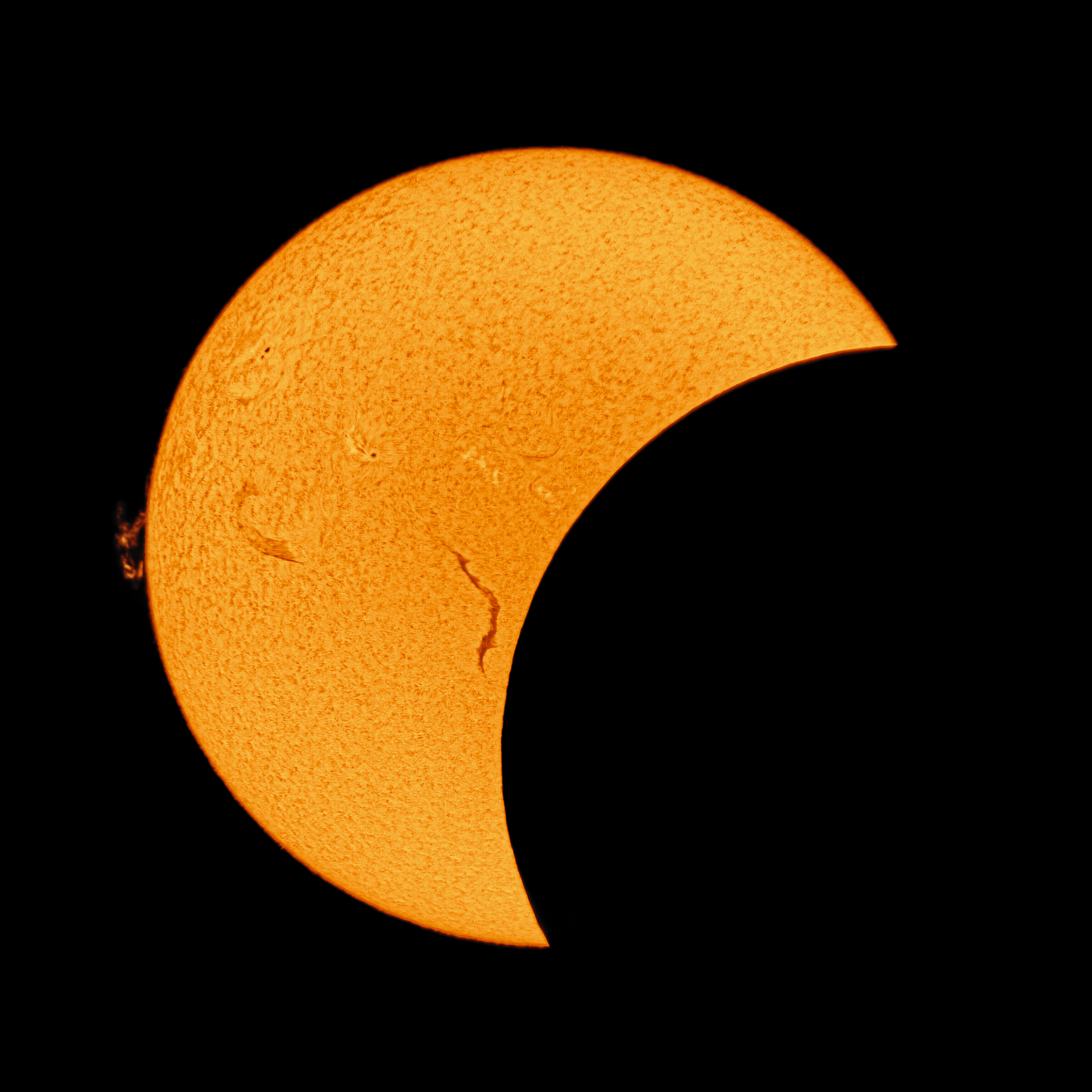 Partielle Sonnenfinsternis im H-alpha-Licht mit Protuberanz am Sonnenrand und scharfer Mondkante vor der Chromosphäre